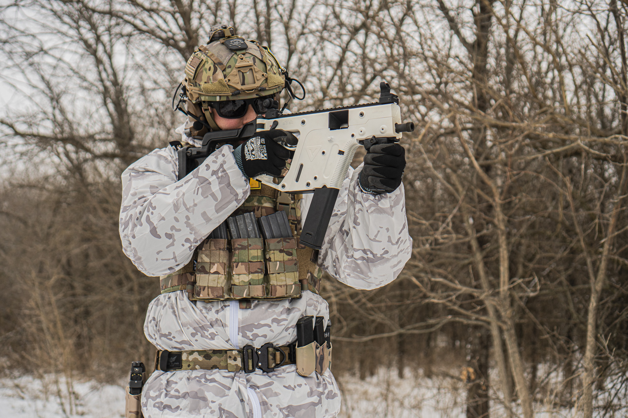 Man in the snow wearing military gear and shooting white KRISS Vector