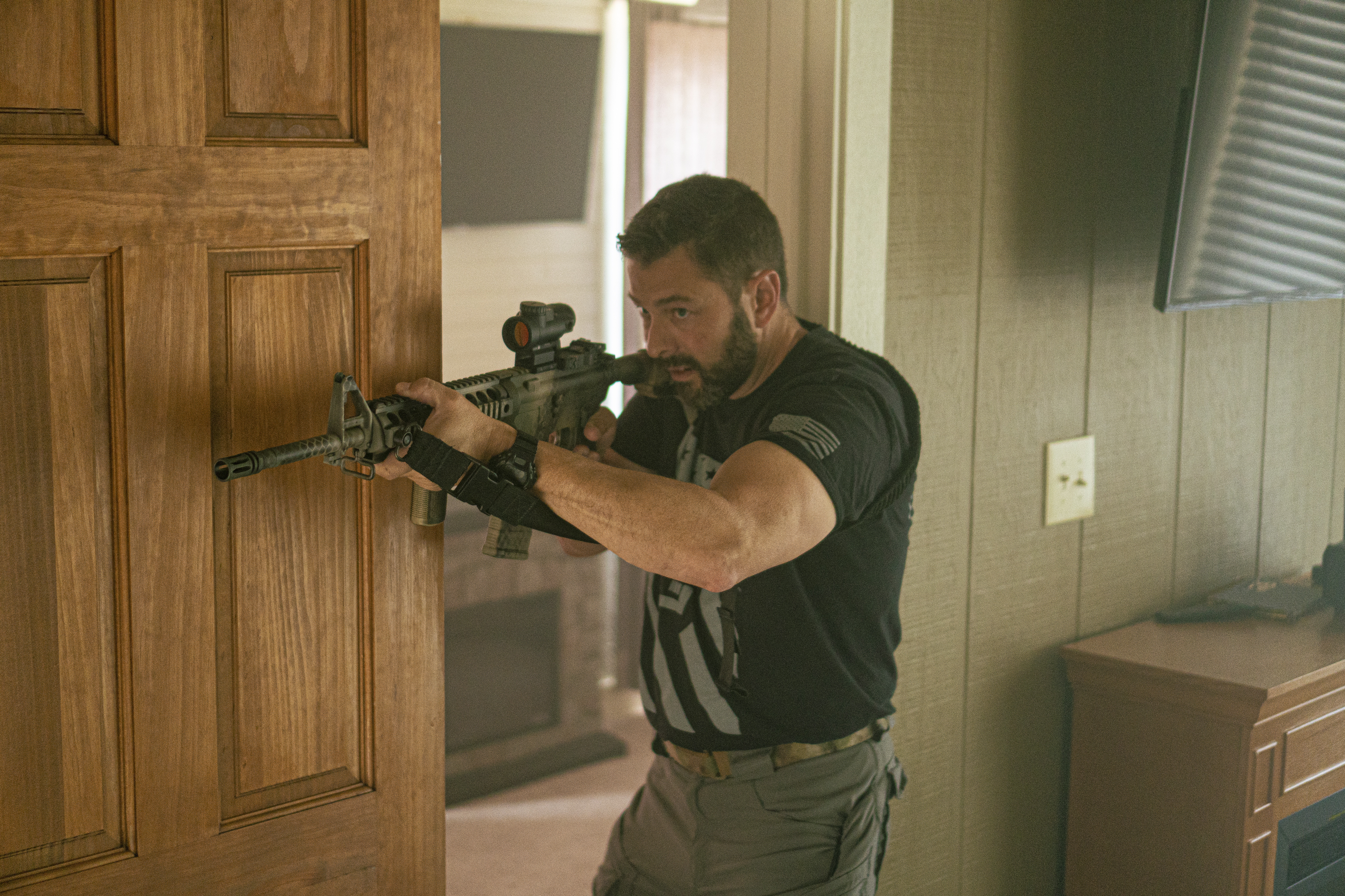 Man clearing doorway with AR15 in a house