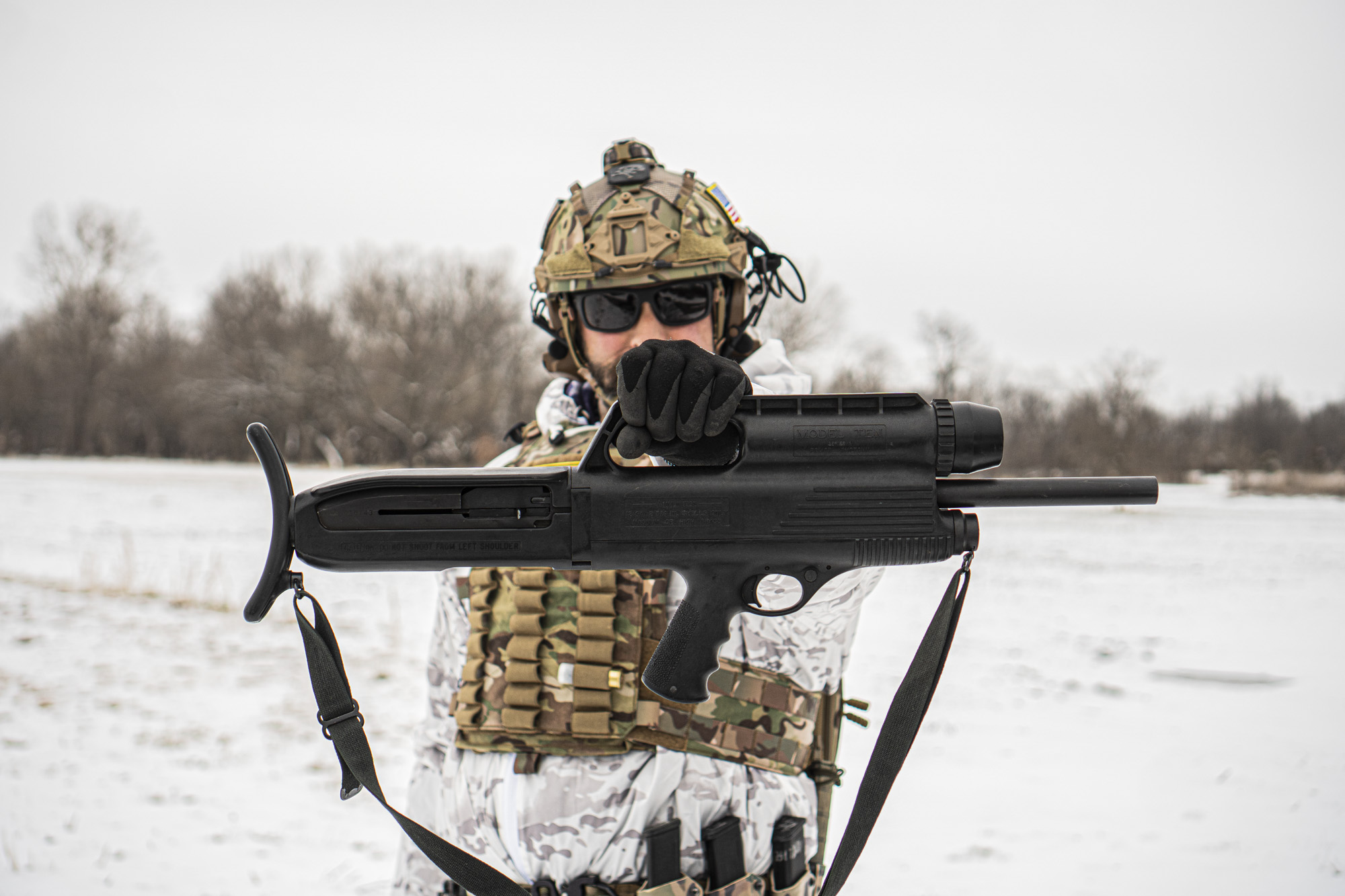 Man in tactical gear holding up a model 10 a shotgun